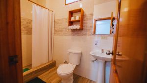 Baño completo de la Suite 23 en Central Suites, con lavabo, inodoro y ducha con cortina.