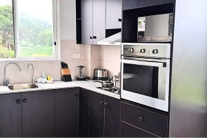 "Modern and fully equipped kitchen in the Ocean Breeze Suite, featuring stainless steel appliances and a sleek design."