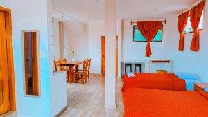 Vista general de la Suite 23 en Central Suites, mostrando la habitación, comedor y ventanas con cortinas cálidas.