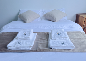 Spacious master bedroom with a comfortable bed, soft lighting, and elegant decor for a restful stay.