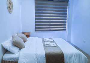 Spacious master bedroom with a comfortable bed, soft lighting, and elegant decor for a restful stay.